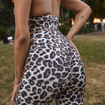 Close-up of a woman’s lower back and hips, wearing leopard-print scrunch leggings, highlighting the form-fitting design and pattern.