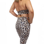 A close-up of a woman’s lower body in leopard-print leggings, emphasizing the fit and design details of the scrunch-back style, perfect for an energetic, fashionable fitness look.