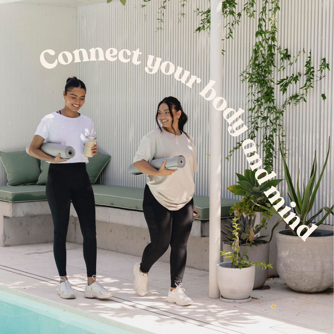 Two women standing outdoors, enjoying a light-hearted moment while engaging in a mindful movement session, promoting the message "Connect your body and mind."