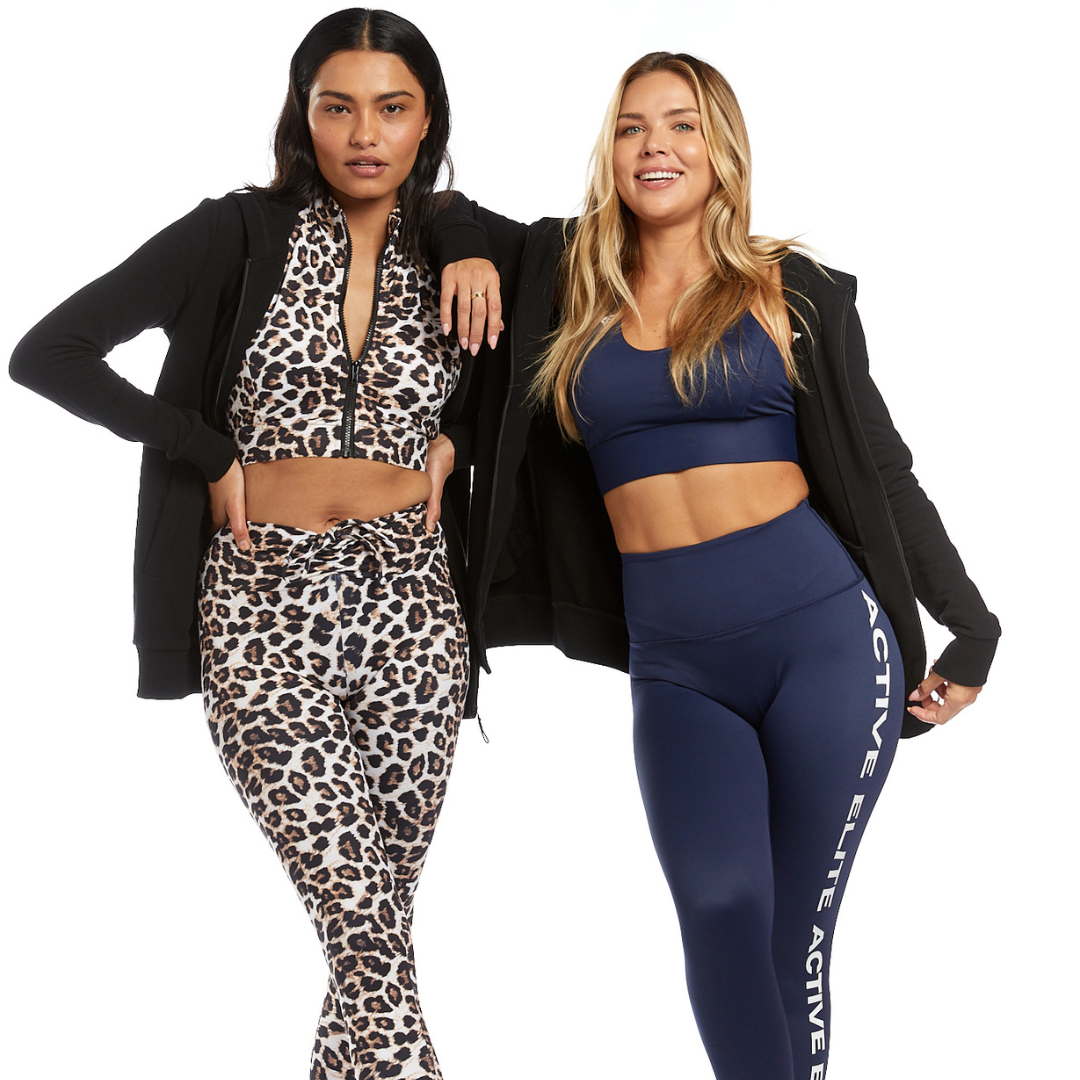 Two women standing confidently in stylish activewear. Both exude confidence and strength, embodying body positivity and empowerment.