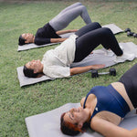 A woman doing yoga outdoors with other participants, focusing on wellness, relaxation, and the versatility of activewear.