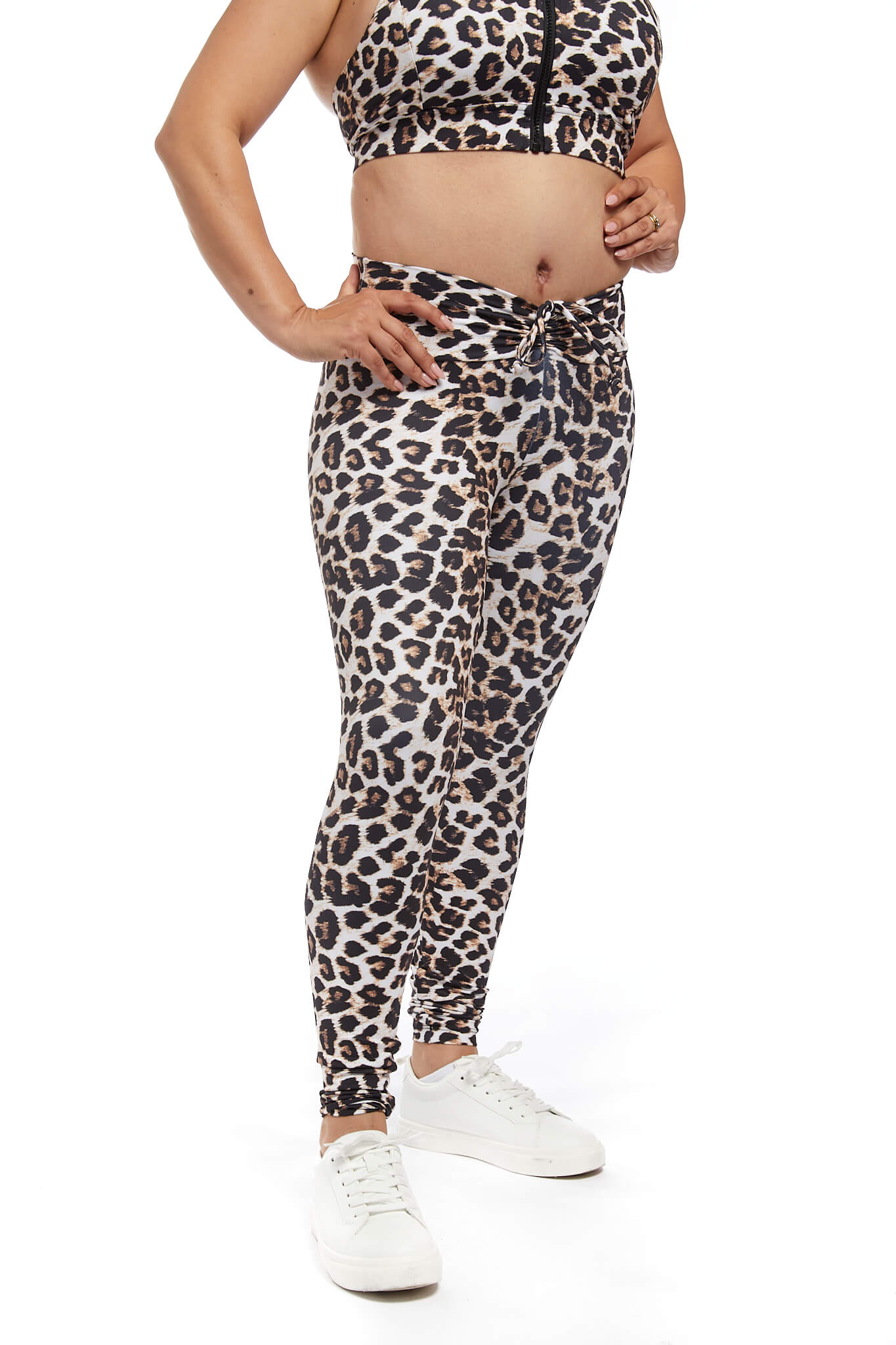 close up of woman wearing leopard print scrunch activewear leggings. Hands are on hips. White background