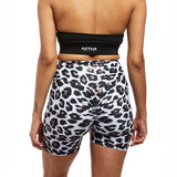 A back view of a woman wearing leopard-print scrunch-back shorts and a black crop top. The close-up emphasizes the form-fitting, stylish design of the activewear set.